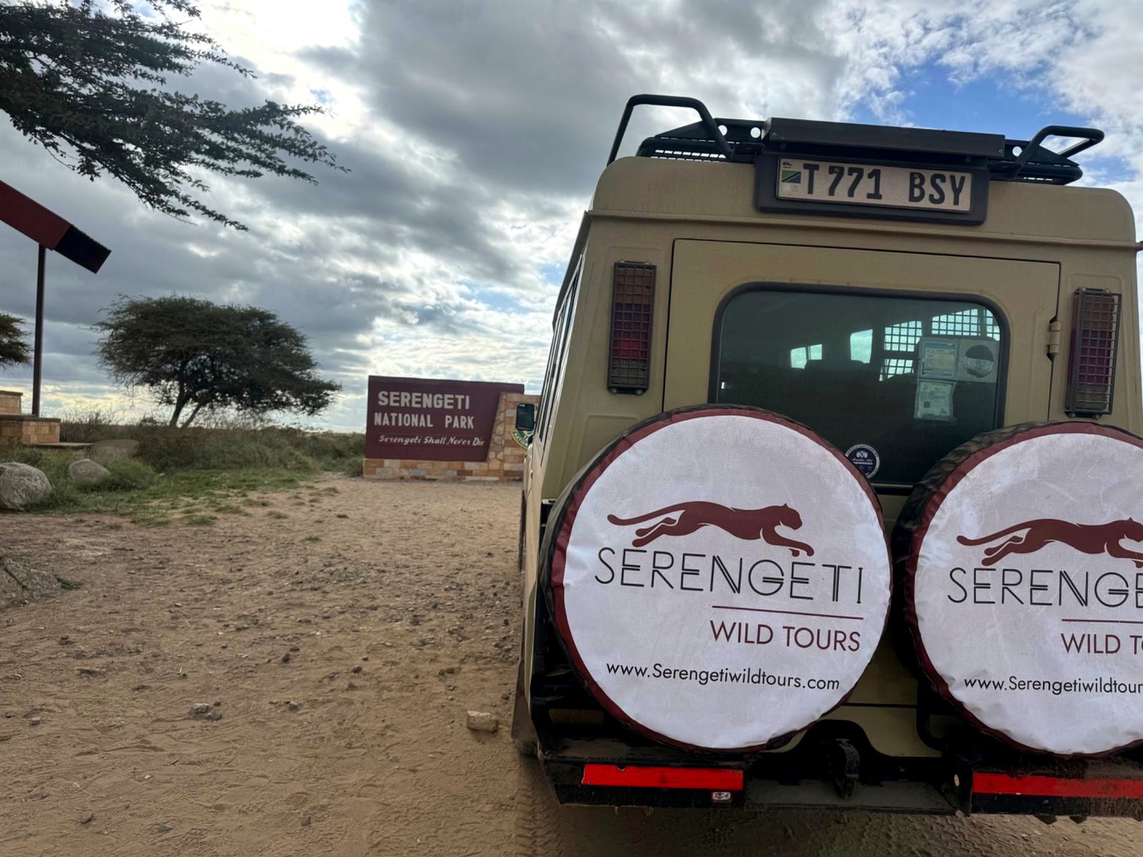 Serengeti Wild Tours safari Land Cruiser at a national park gate